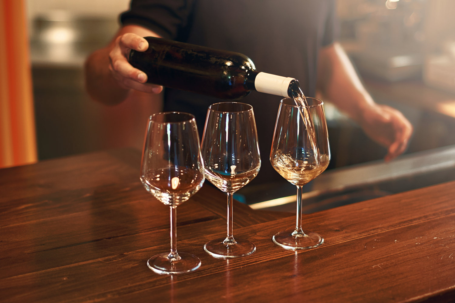 Person pouring wine into a glass