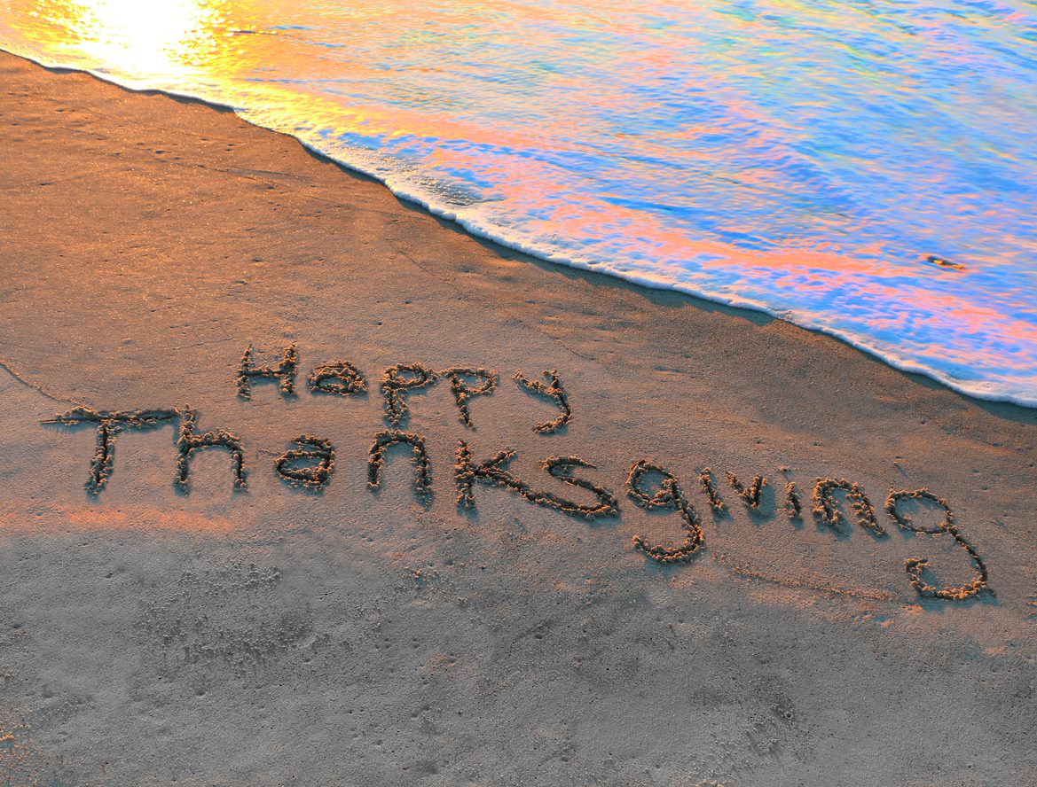 happy thanksgiving in the sand with ocean water rising